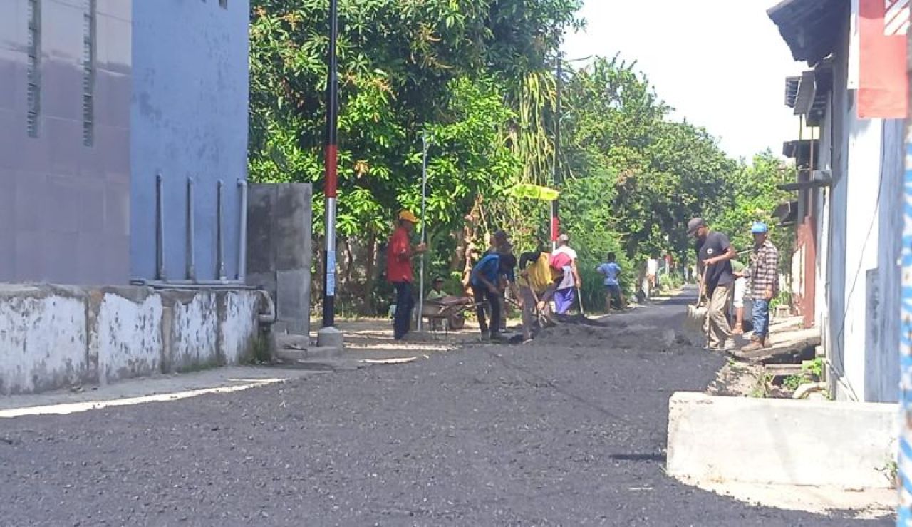 Pekerja melakukan pengaspalan jalan lingkungan di dusun Kemuning, desa Tanggungan, Gudo Kabupaten Jombang secara manual tanpa menggunakan alat berat. Foto: Syarif