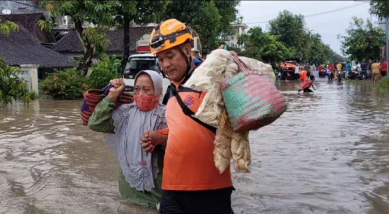 Anggota BPBD Kabupaten Madiun  datang ke lokasi, membantu warga terdampak banjir. Foto: Ono