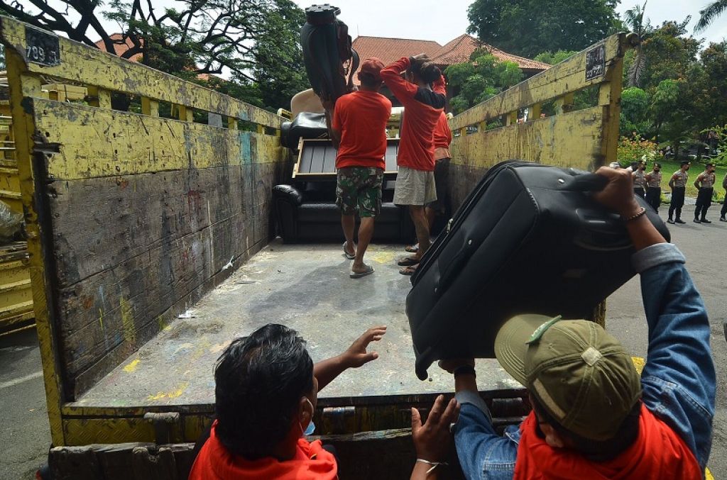 Kuli angkut dan pegawai mengeluarkan dan mengangkut barang-barang milik Hotel Singgasana ke Truk