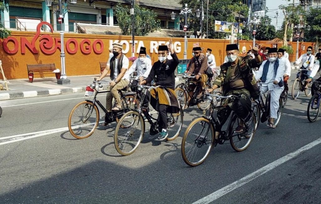 Bupati Sugiri dengan bersarung dan berpeci tampak menikmati rute ngontel bareng santri.