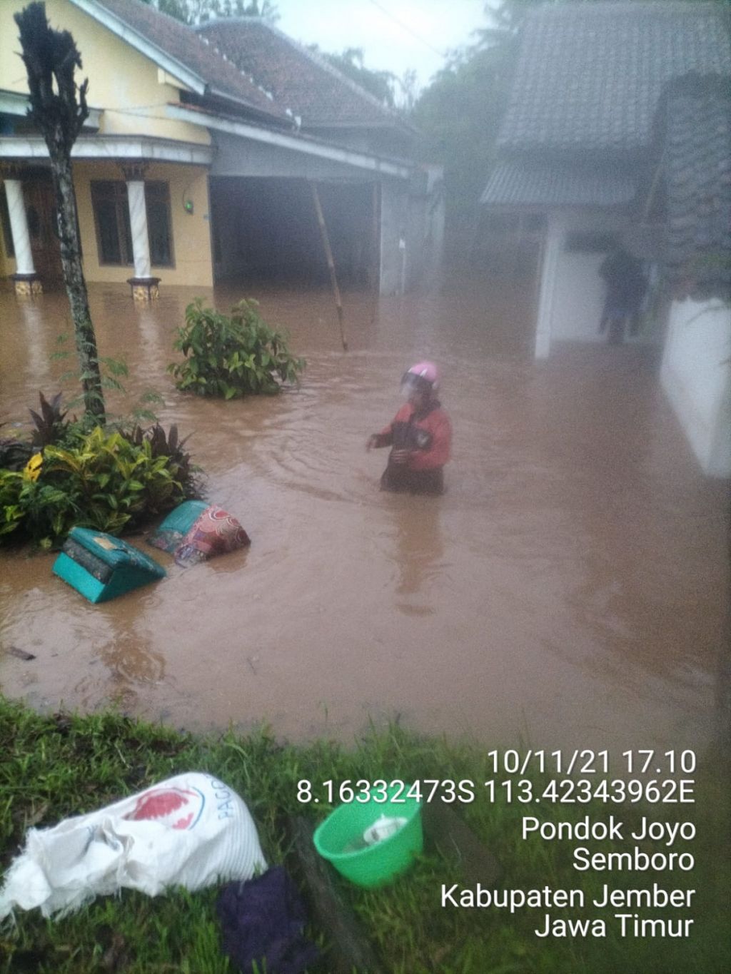 Seorang warga mencoba menyelamatkan diri dari kepungan banjir.
