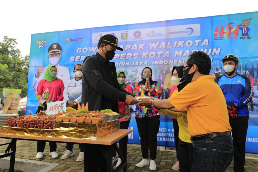 Walikota Madiun, Maidi memberikan potongan tumpeng kepada wartawan.