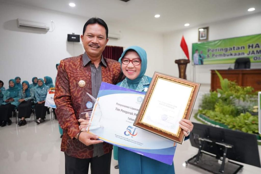 Walikota Madiun, Maidi dan Ketua TP PKK Kota Madiun, Yuni Setyawati Maidi menunjukkan penghargaan juara satu dalam penyusunan program terbaik Jawa Timur kategori pemerintah kota. 