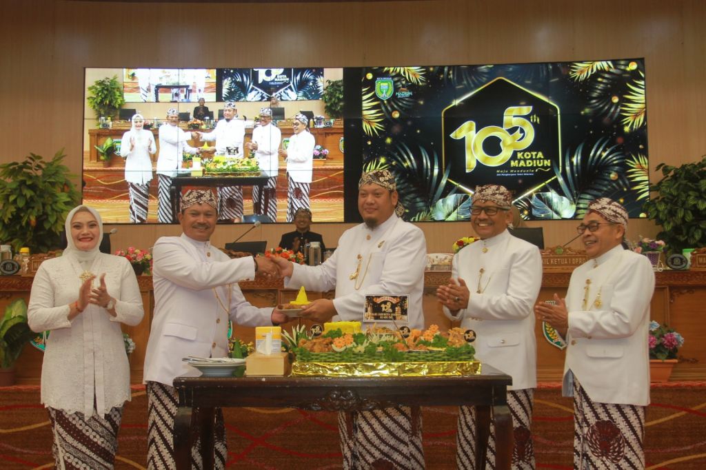 Ketua DPRD Andi Raya Bagus Miko Saputra memberikan tumpeng kepada Wali Kota Madiun, Maidi saat rapat pripurna istimewa peringatan Hari Jadi ke-105 Kota Madiun.