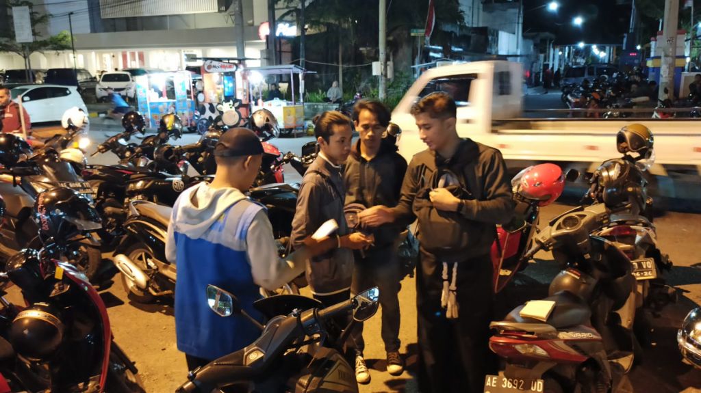 Petugas Jukir saat menarik parkir kendaraan saat event Grebeg Suro. Foto:Zainul