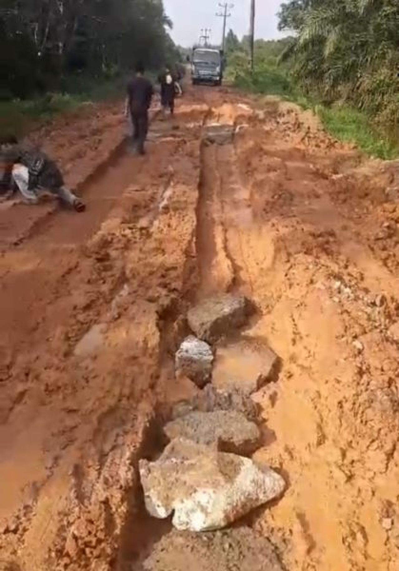 Batu yang ditaruh di atas jalan, tak banyak membantu. Foto: Andre