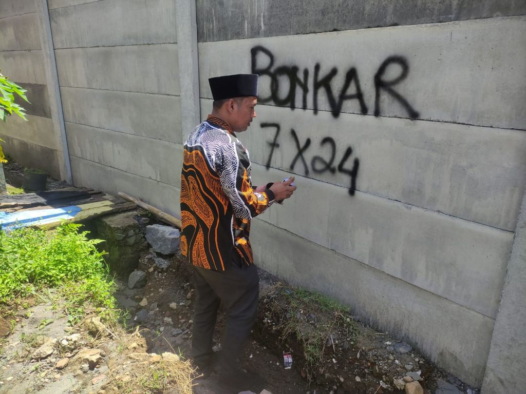 Anggota DPRD Kabupaten Malang saat memberi tanda di pagar tembok Perumahan Green Village dengan tulisan 